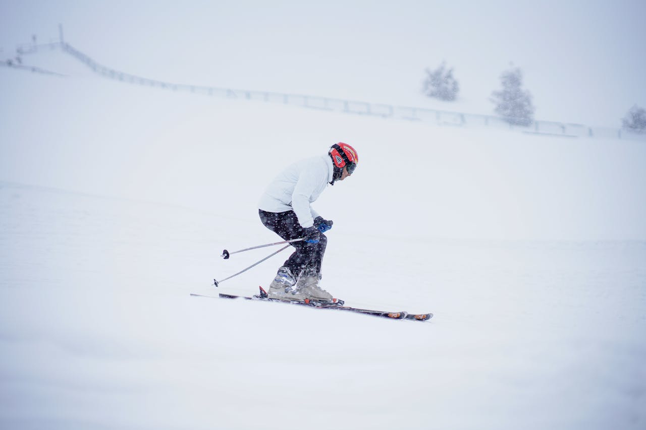 A skier in a red helmet navigating snowy slopes in Gulmarg's winter wonderland.